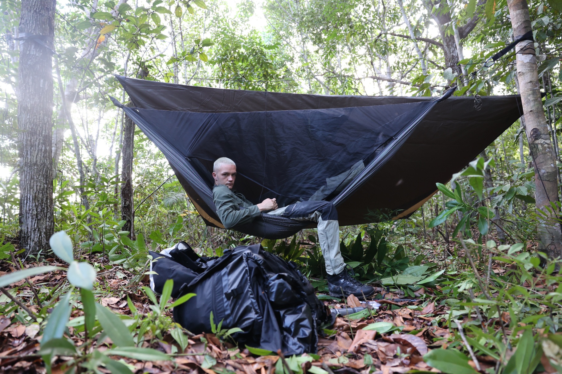 Trainee in a hammock shelter system at a jungle camp