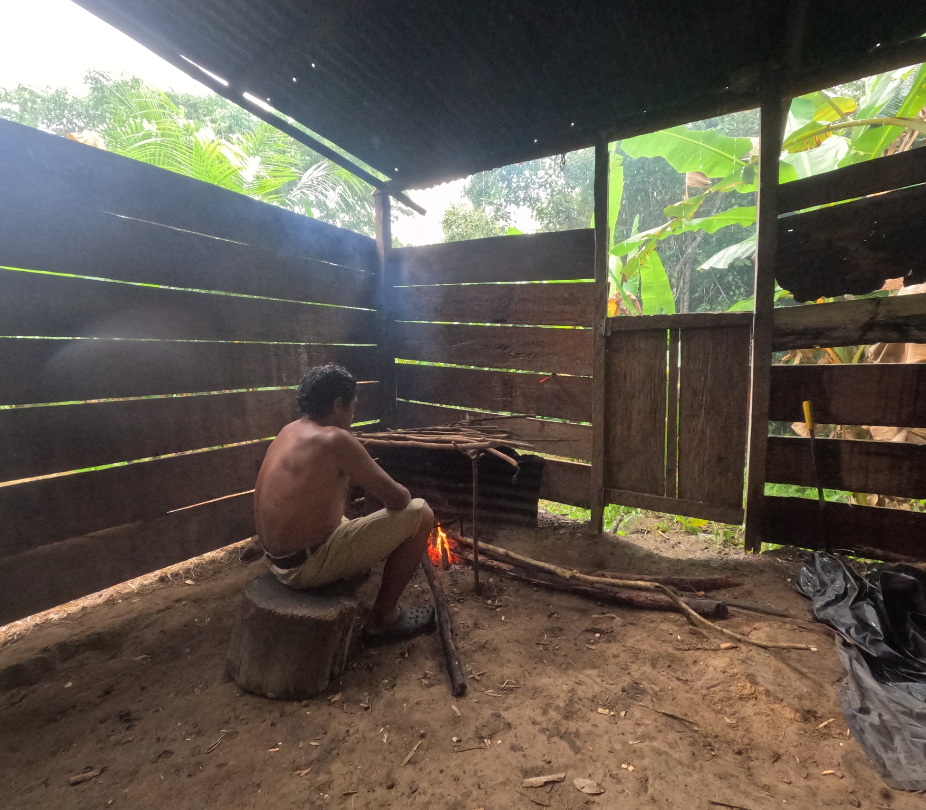 Field shelter and cooking fire under a rain roof in the jungle
